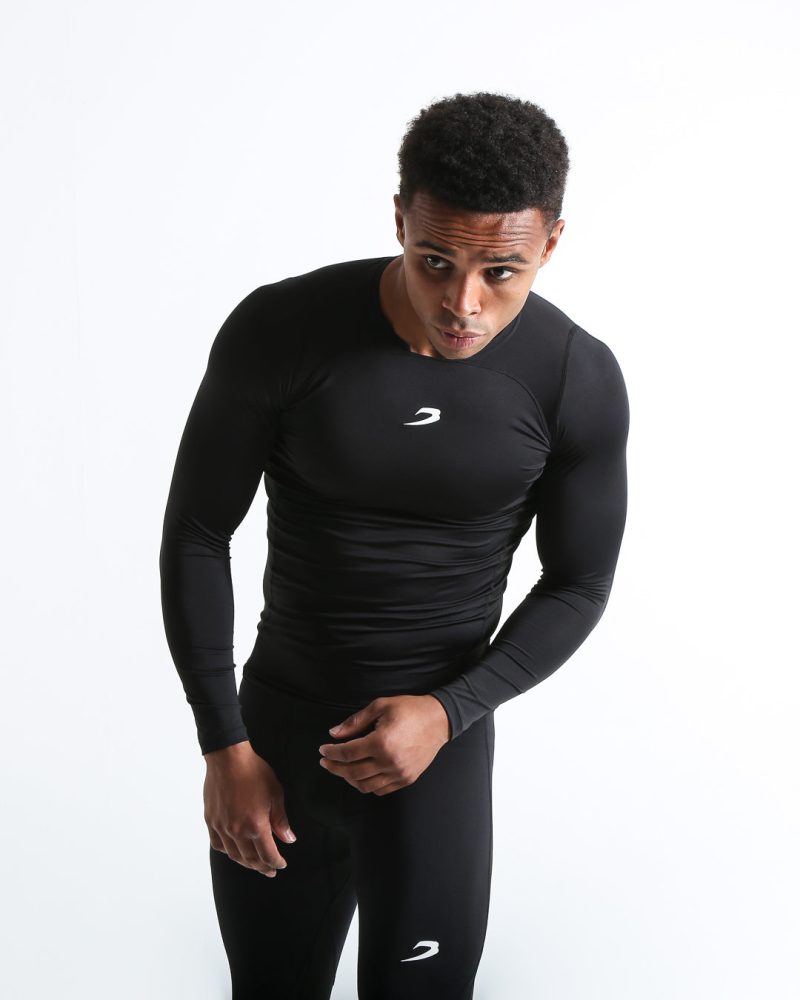 Man in black compression long sleeved t-shirt made from mesh fabric and targeted ventilation panels with white boxraw strike logo on the chest